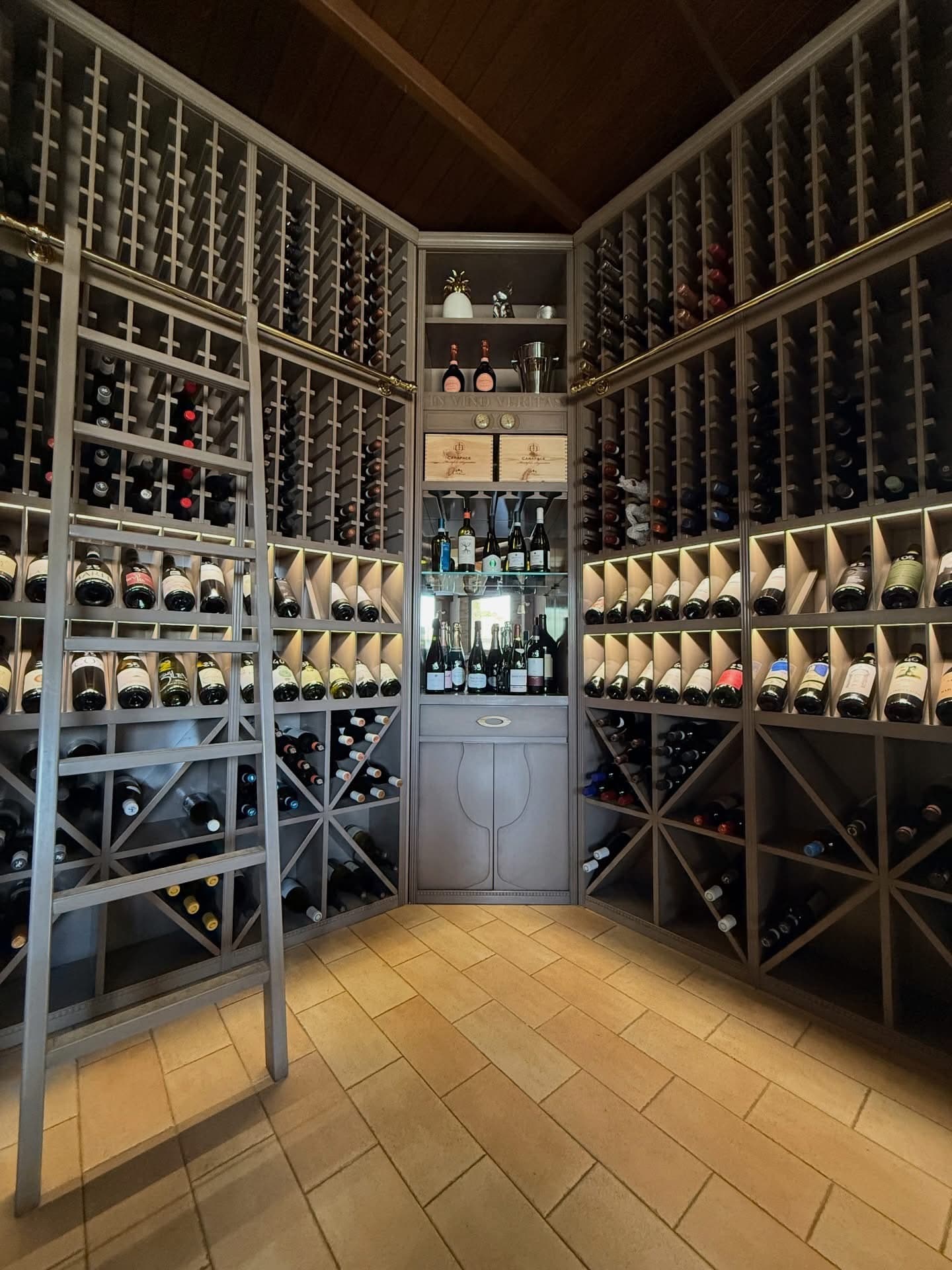 La cantina con la scala e le pareti di bottiglie
