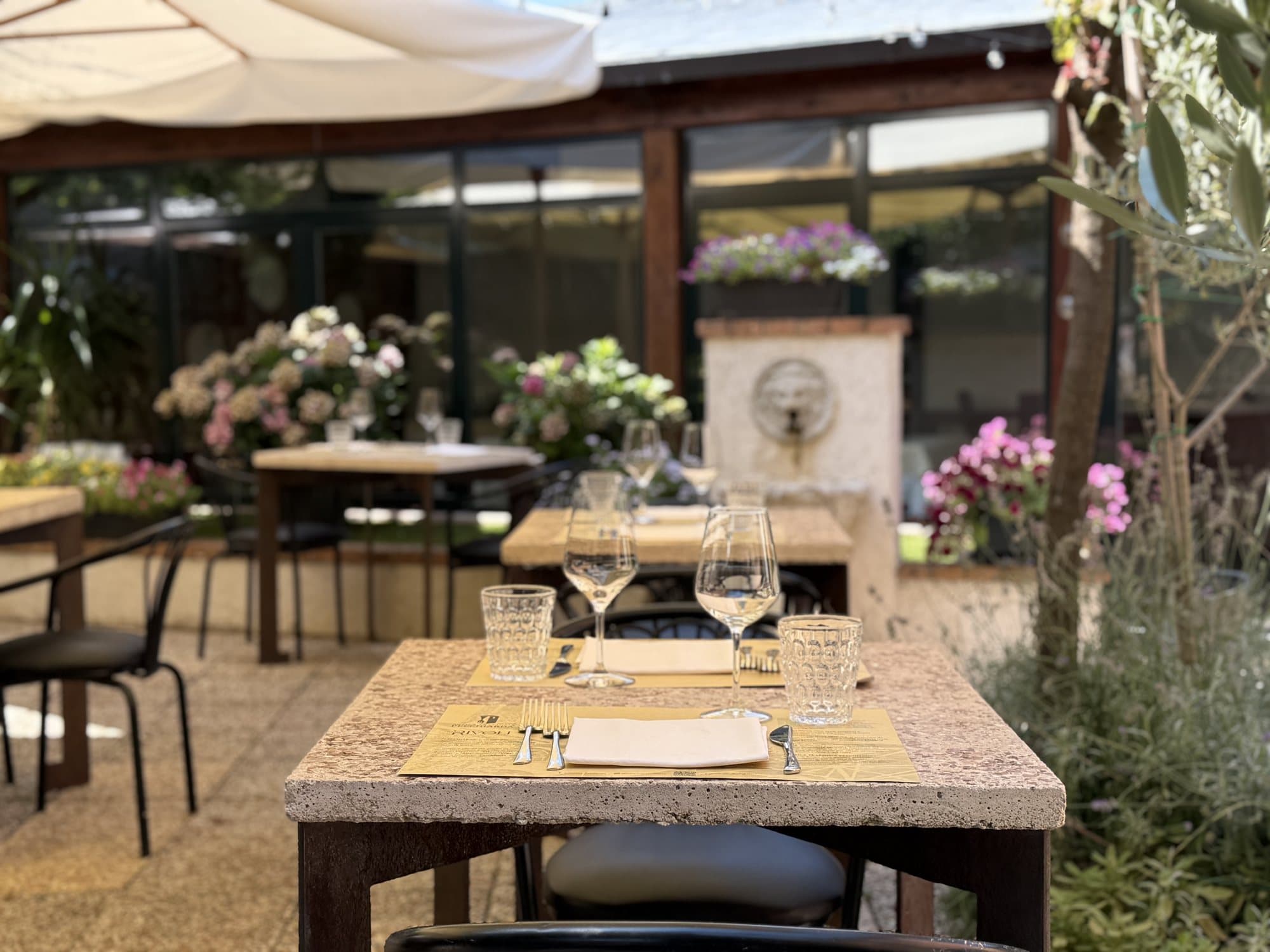 La corte di giorno, tavoli e fiori sotto il pergolato