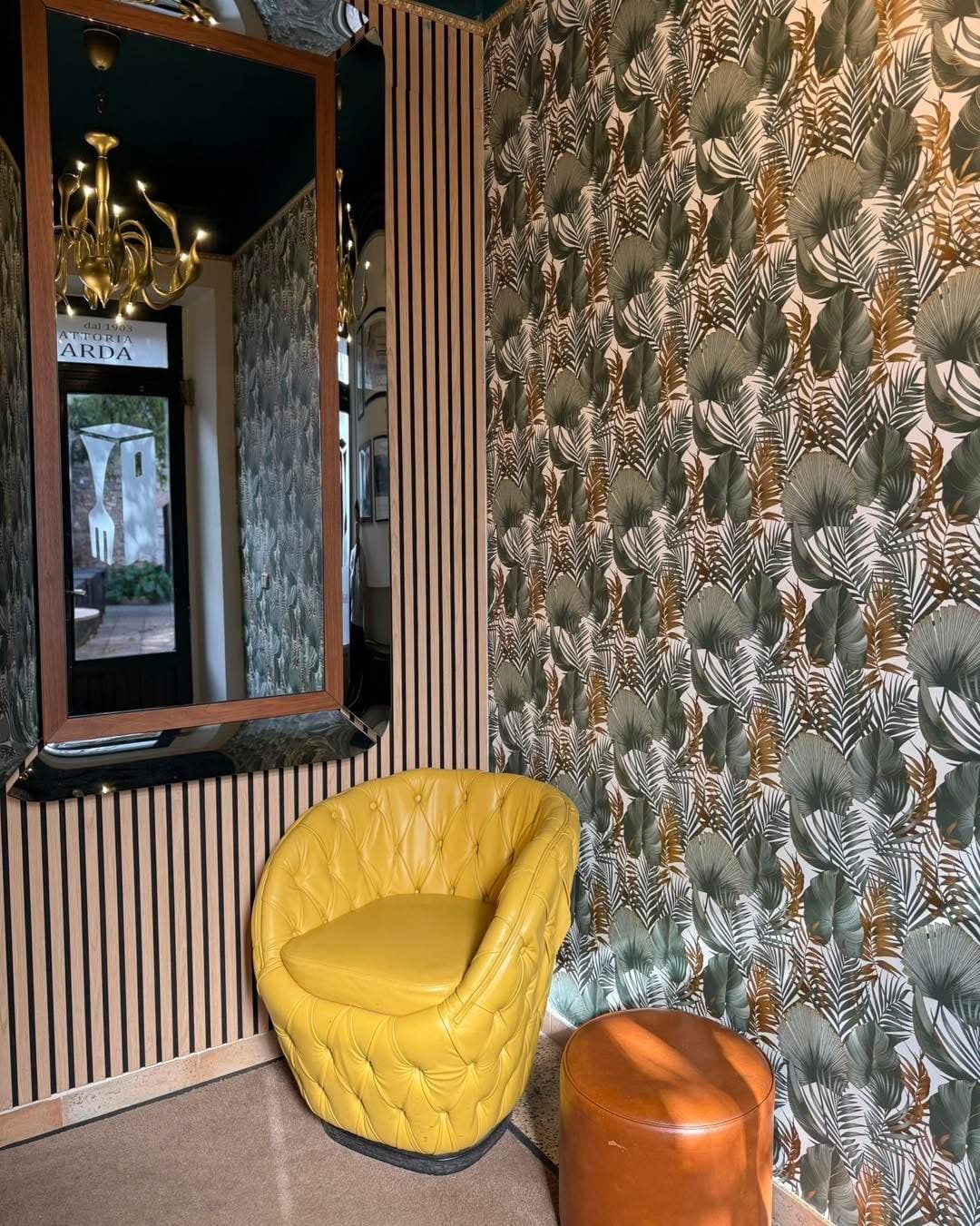 L'angolo con la poltroncina gialla e lo specchio che riflette l'insegna Arda