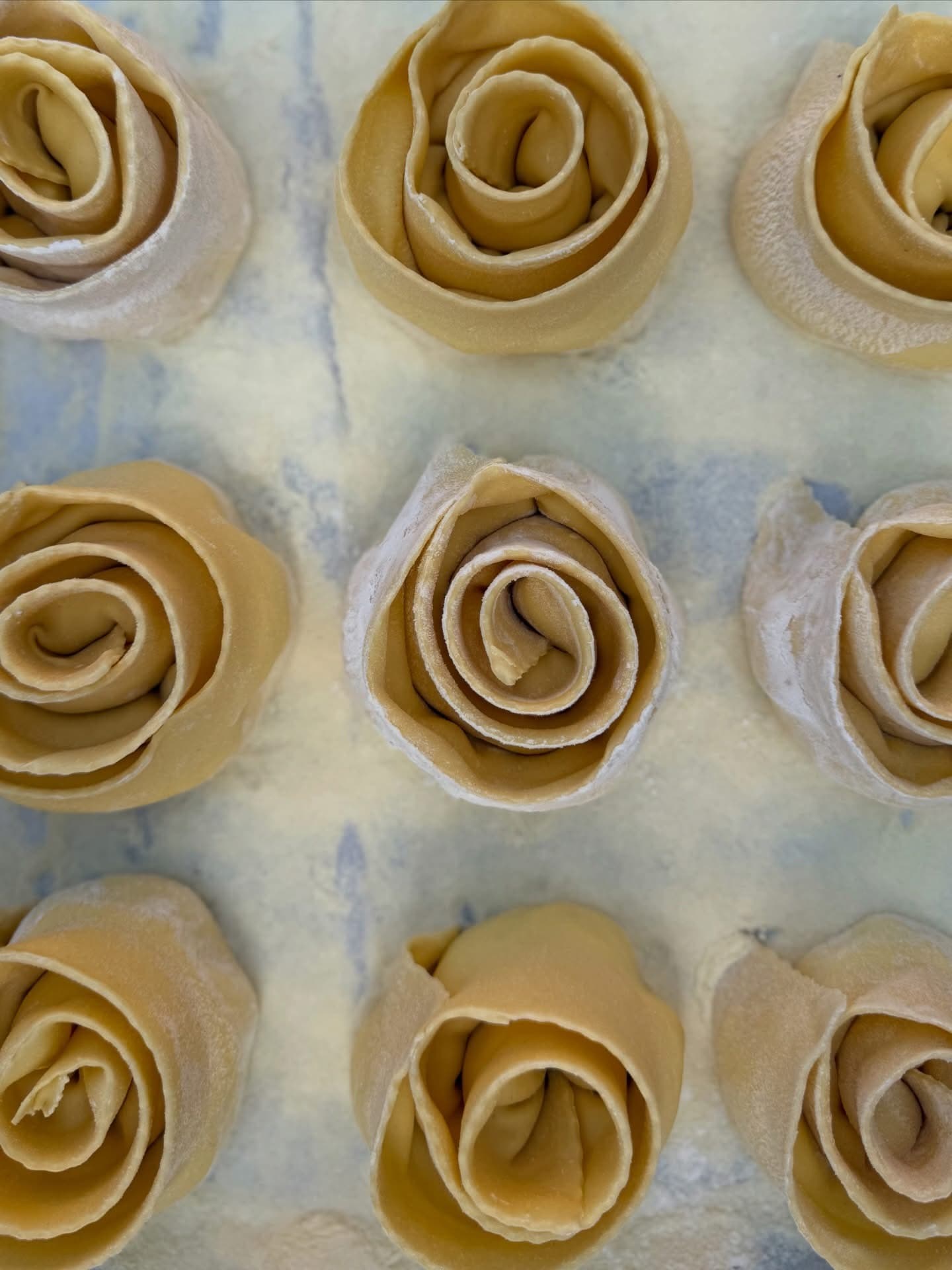 Rose di pasta fresca stese sul piano infarinato del laboratorio