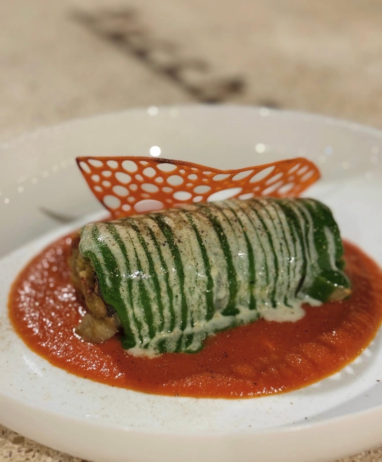La parmigiana avvolta nel verde, su salsa di pomodoro