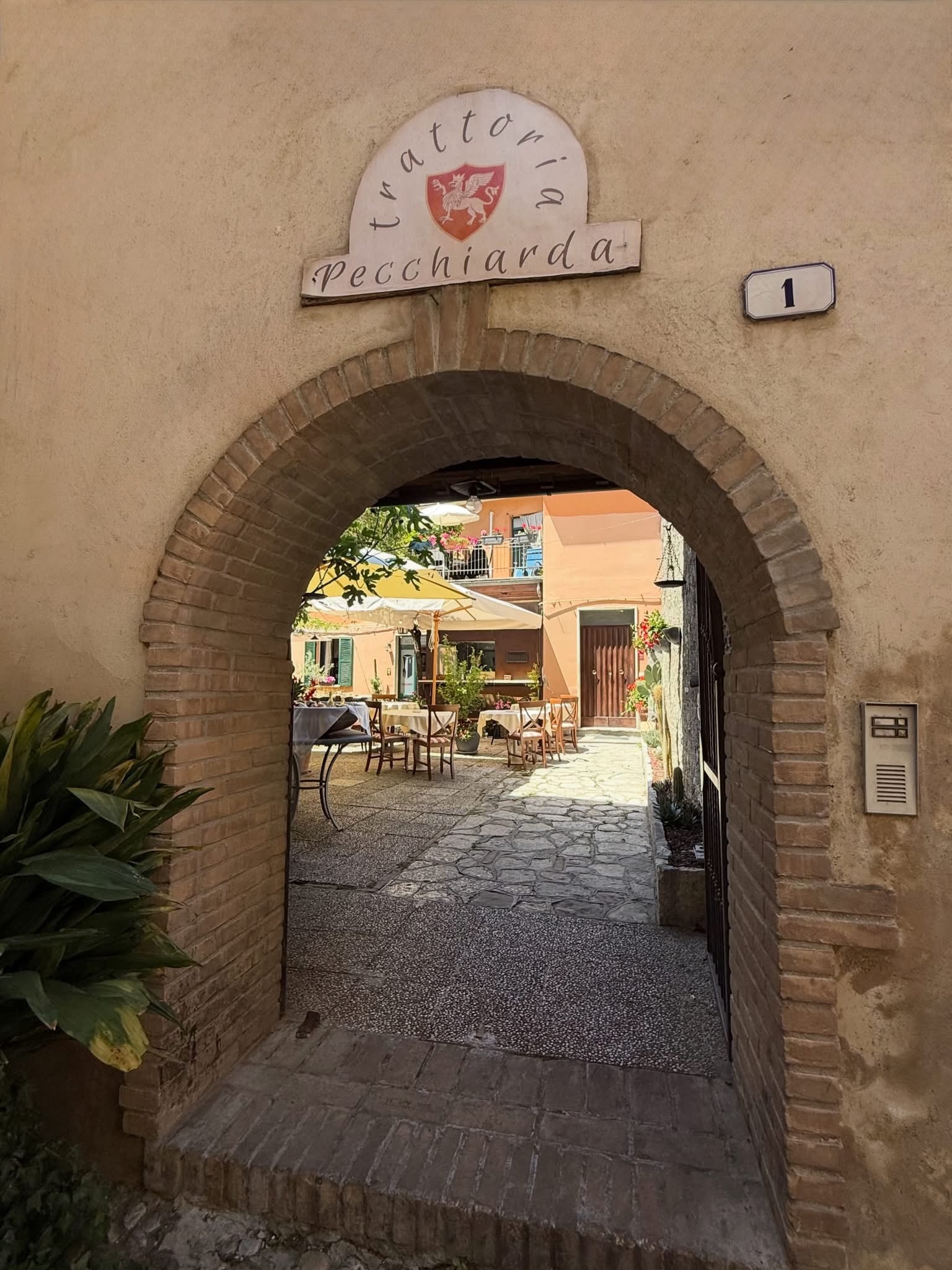 L'arco d'ingresso dell'Antica Trattoria Pecchiarda in Vicolo San Giovanni, con la corte oltre l'arco